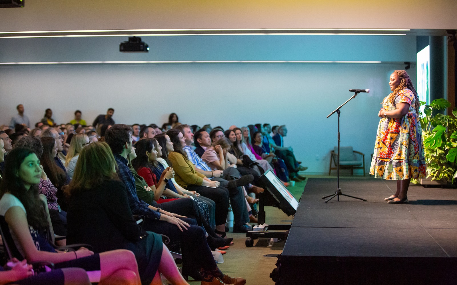 Speaker addressing a diverse audience on stage