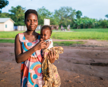 Woman holding a baby outdoors