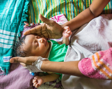 Hands cradling a newborn baby