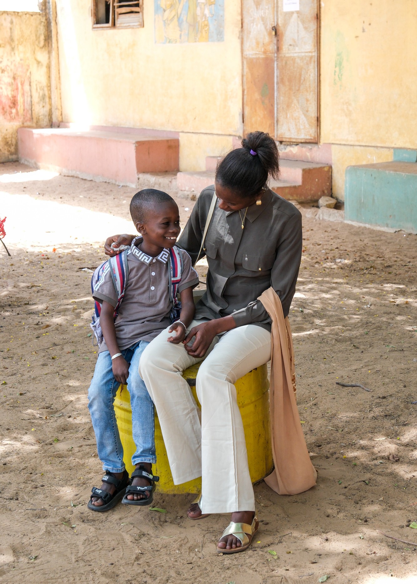 Student Manssour Fall and his mother, Aminata Ba, pose for a portrait after class which is part of the Associates in Research and Education for Development (ARED) program in Dakar, Senegal on July 15, 2025.