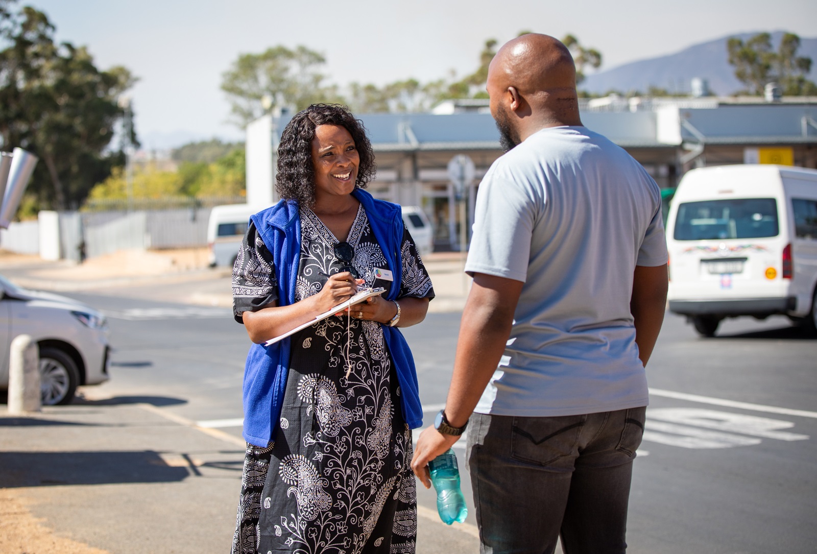 A community health worker speaks with a visitor at a tuberculosis trial site