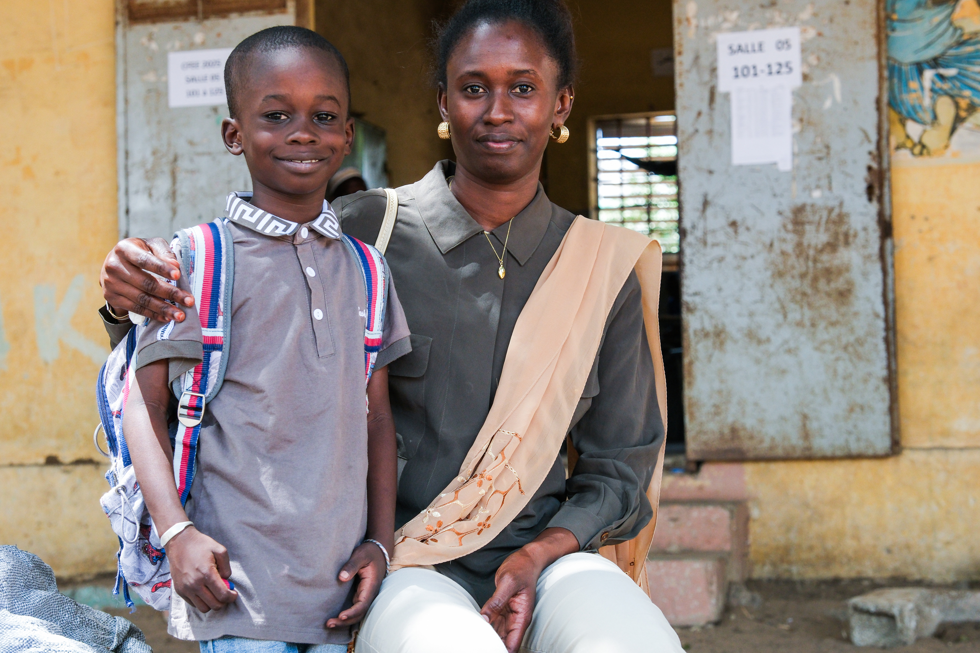 Manssour Fall and his mother, Aminata Ba, pose for a portrait after class that is part of the Associates in Research and Education for Development (ARED) program in Dakar, Senegal.