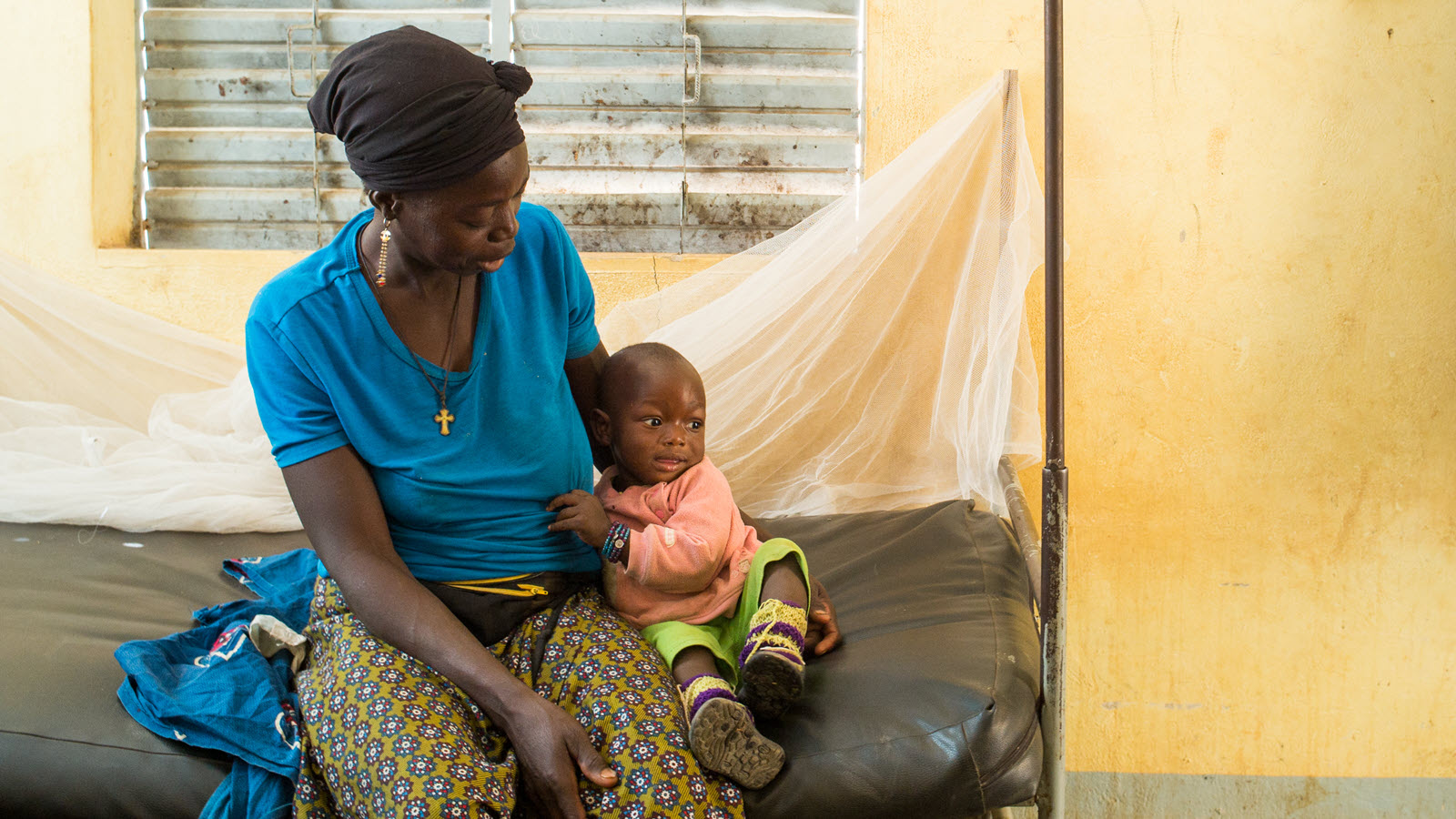 A health worker holds a child during a clinic visit