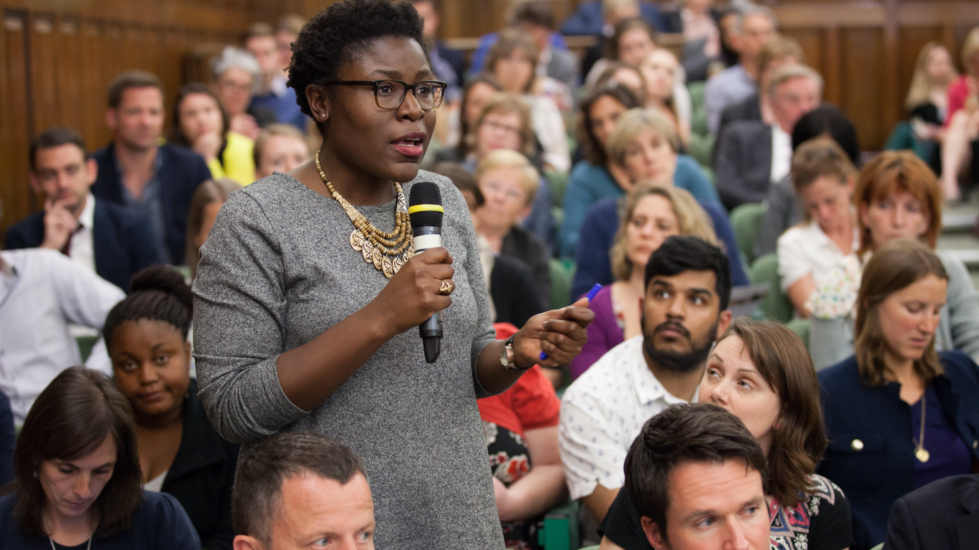 A participant asks a question during a discussion on family planning and the rights of girls and women.
