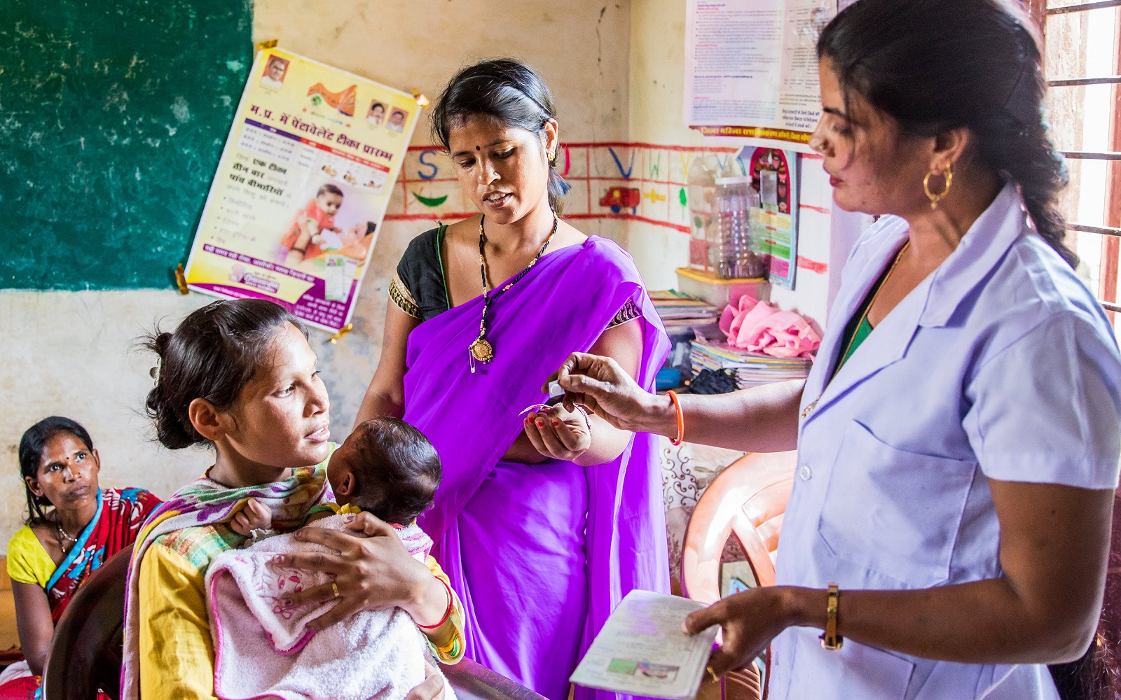 A community health worker speaks with women and children in India.