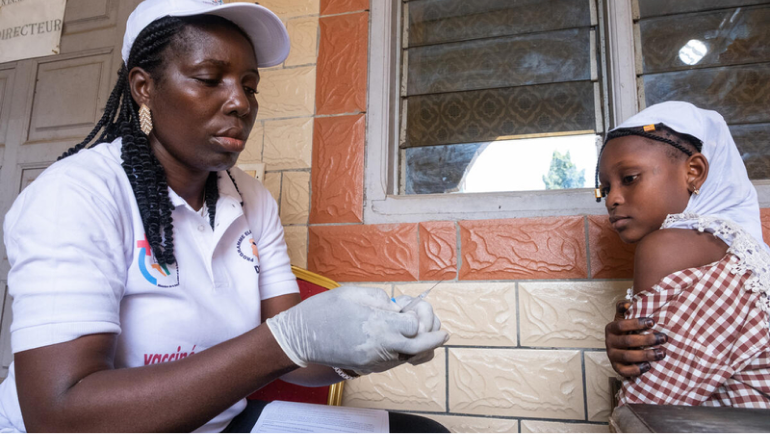 A health worker speaks with a young girl during a community visit in Kenya.