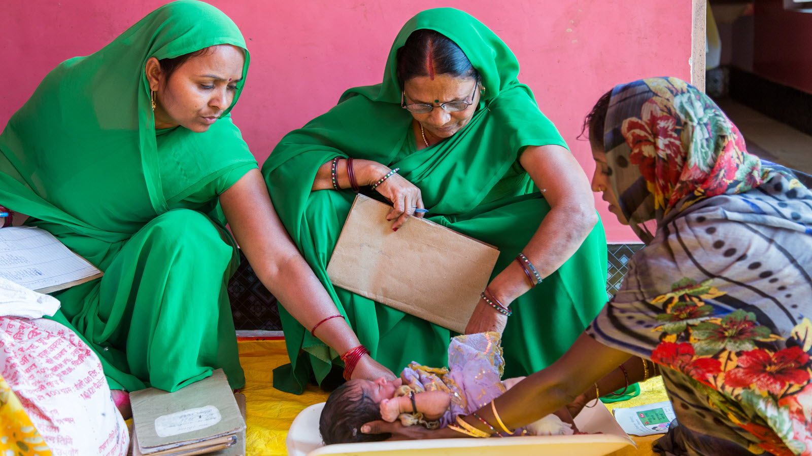 Anganwadi workers weigh a child on Village Health Nutrition Day in Uttar Pradesh.