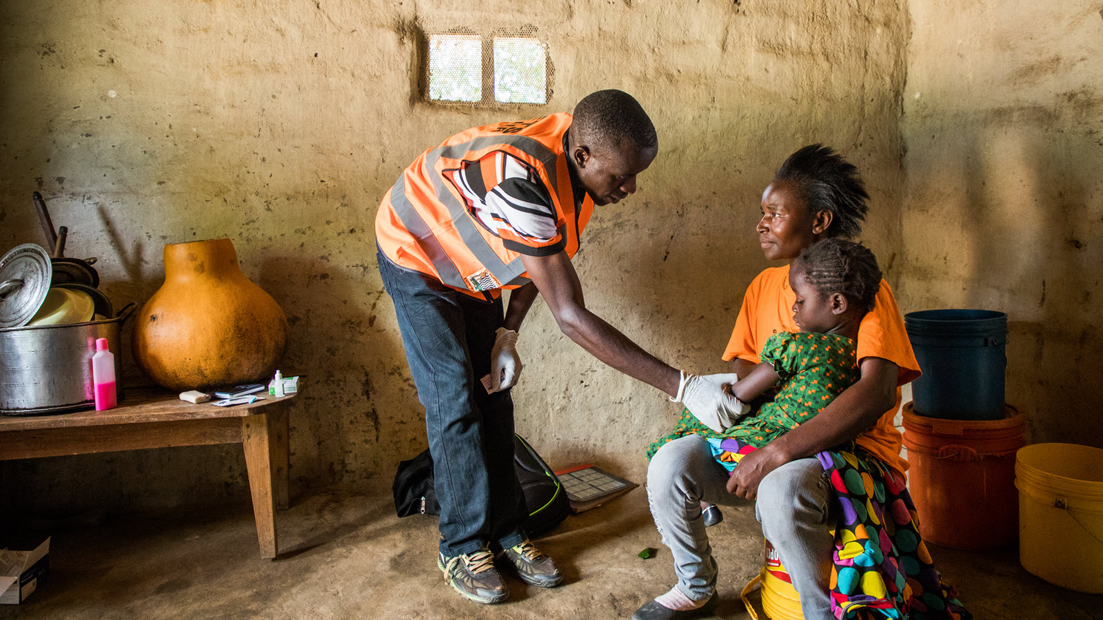A community health volunteer visits a child with malaria in Zambia.